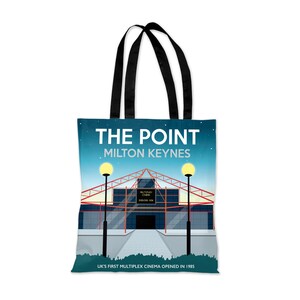 Könnte beinhalten: Eine blaue und weiße Einkaufstasche mit einer Grafik des The Point Kinos in Milton Keynes, England. Der Text "THE POINT MILTON KEYNES" ist in Weiß auf der Tasche gedruckt. Der Text "UK'S FIRST MULTIPLEX CINEMA OPENED IN 1985" ist in Weiß am unteren Rand der Tasche gedruckt.