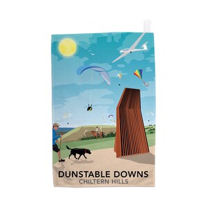 Puede incluir: Una ilustración colorida de Dunstable Downs en las colinas de Chiltern. La imagen presenta un edificio marrón, un cielo azul con nubes blancas, un sol amarillo, un planeador, parapentes y personas caminando y montando a caballo.