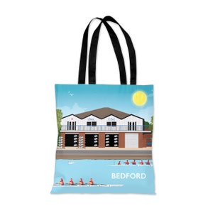 Puede incluir: Una bolsa de tela azul y blanca con un gráfico de una casa de botes y remeros en el agua. La casa de botes tiene las palabras "Star Club" en la parte delantera. El texto "BEDFORD" está impreso en la bolsa.