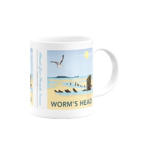 Könnte beinhalten: Weiße Keramiktasse mit einer bunten Illustration einer Strandszene mit einem Schiffswrack und einer Möwe, die darüber fliegt. Der Text "Worm's Head" ist auf die Tasse gedruckt.