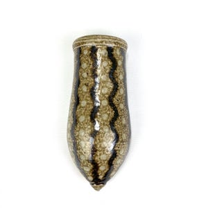 May include: A brown and white ceramic wall vase with a speckled and wavy pattern.