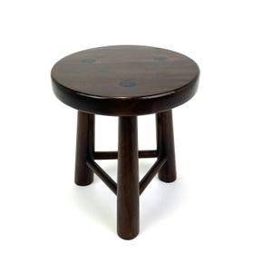 May include: A dark brown wooden stool with a round seat and three legs. The legs are connected by a triangular support structure. The stool is made of a dark wood with a smooth, polished finish.