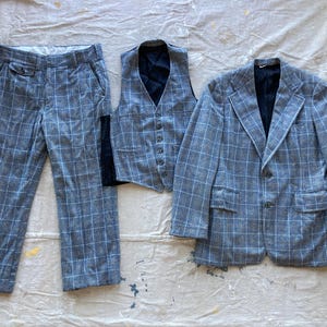 Puede incluir: Un traje de tres piezas en un patrón de cuadros azul y blanco. El traje incluye una chaqueta, un chaleco y pantalones.