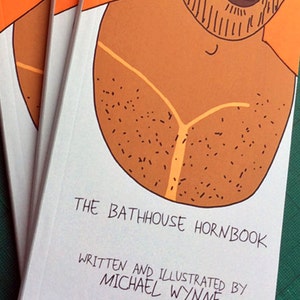 May include: Several copies of a book titled "The Bathhouse Hornbook" featuring a cartoon illustration of a torso on the cover. The illustration is in shades of brown and orange, with the text "Written and Illustrated by Michael Wynne" below the title.