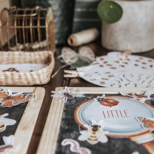 Peut inclure: Un ensemble de cartes éducatives d'apprentissage représentant divers insectes, notamment des papillons, des abeilles, des araignées et des coccinelles. Les cartes sont imprimées sur du papier cartonné blanc et ont une bordure noire. Les cartes sont disposées en cercle sur une table en bois. Les cartes sont étiquetées avec le mot "petit".
