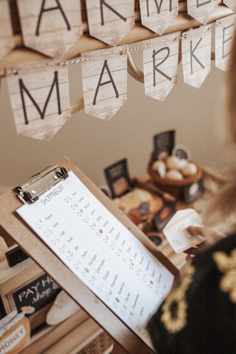 May include: A market scene with a wooden banner that reads "MARKET". A clipboard with a shopping list is in the foreground. The list includes items like honey, eggs, and cheese. A person is holding a piece of cheese.
