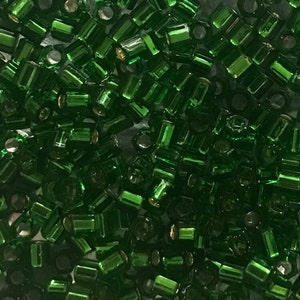 May include: A large quantity of small, green, faceted glass beads. The beads are hexagonal in shape and have a shiny, metallic finish.