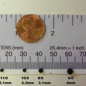 May include: A ruler with inch and millimeter markings, showing the size of six black beads. The beads are labeled with their size in millimeters and inches. The beads range in size from 1.7mm to 4mm.