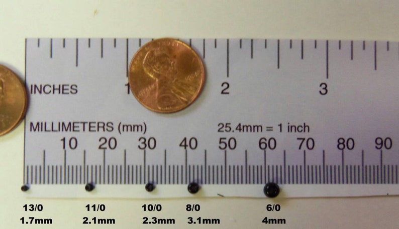 May include: A ruler with inch and millimeter markings, showing the size of six black beads. The beads are labeled with their size in millimeters and inches. The beads range in size from 1.7mm to 4mm.