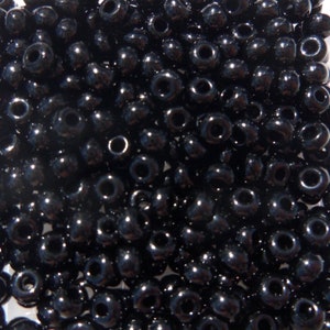 May include: A large quantity of black seed beads. The beads are round and have a shiny finish.