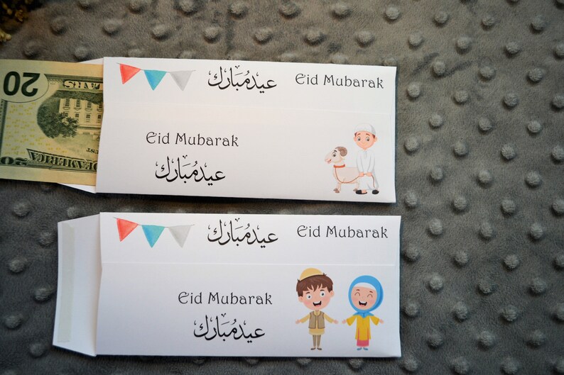 May include: Two white envelopes with colorful flags and Arabic text that says "Eid Mubarak". The envelopes have illustrations of children celebrating Eid. One envelope has a boy holding a lamb and the other has a boy and girl holding hands.