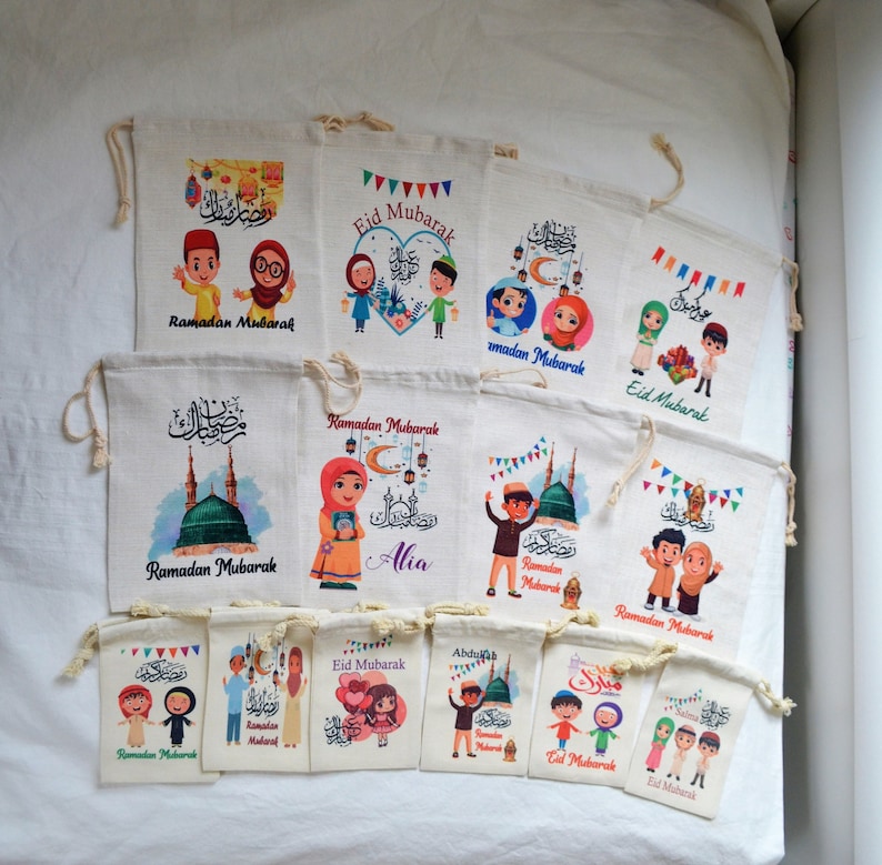 May include: A collection of 12 colorful drawstring bags with various designs featuring cartoon characters, Islamic calligraphy, and the phrase "Ramadan Mubarak" or "Eid Mubarak".