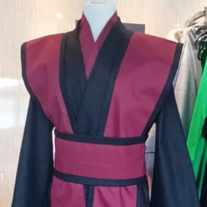 May include: A burgundy and black robe with a wide black belt. The robe has a V-neck and long sleeves.