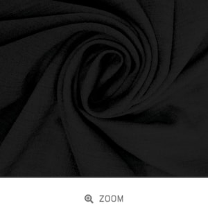 May include: Close-up of black slub viscose fabric. The fabric has a soft, textured look and feel.