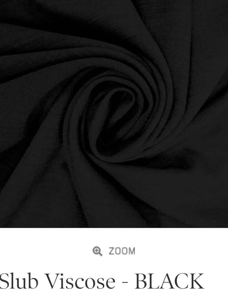 May include: Close-up of black slub viscose fabric. The fabric has a soft, textured look and feel.