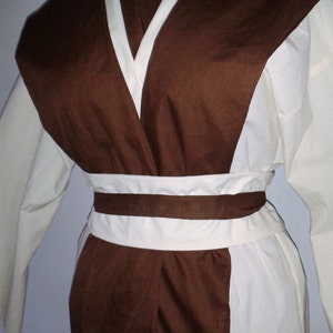 May include: A brown and white robe with a long sleeve and a sash around the waist.