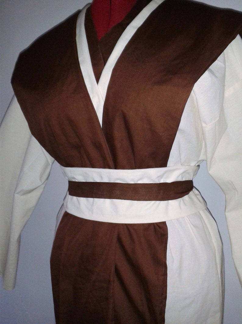 May include: A brown and white robe with a long sleeve and a sash around the waist.