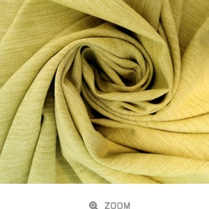 May include: Close-up of a lime green fabric with a slub texture. The fabric is folded and draped, showing the soft, drapey quality.
