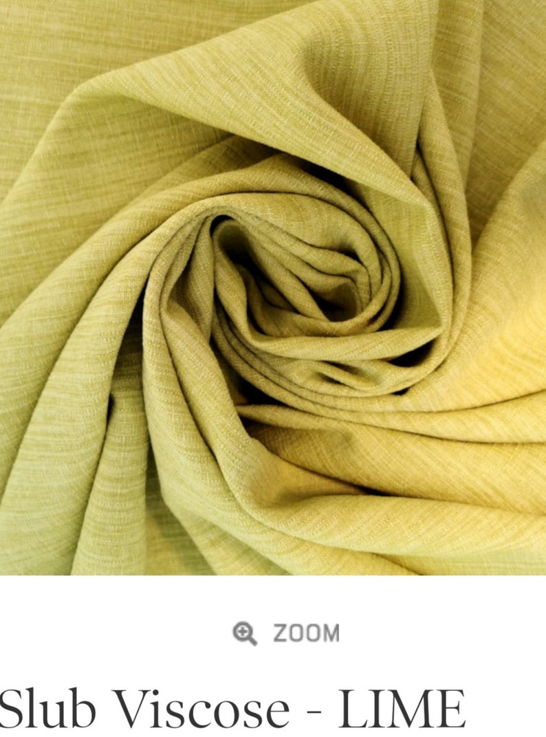 May include: Close-up of a lime green fabric with a slub texture. The fabric is folded and draped, showing the soft, drapey quality.
