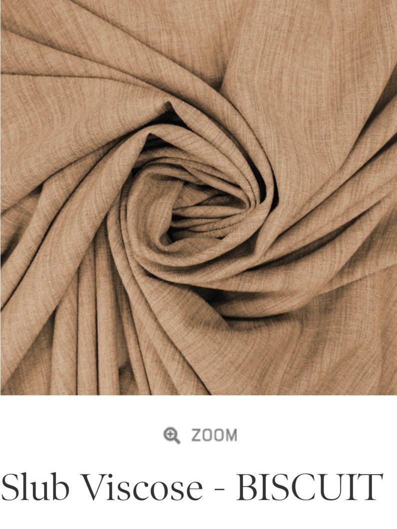 May include: Close-up of a soft, brown fabric with a slub texture. The fabric is called "Slub Viscose - BISCUIT".