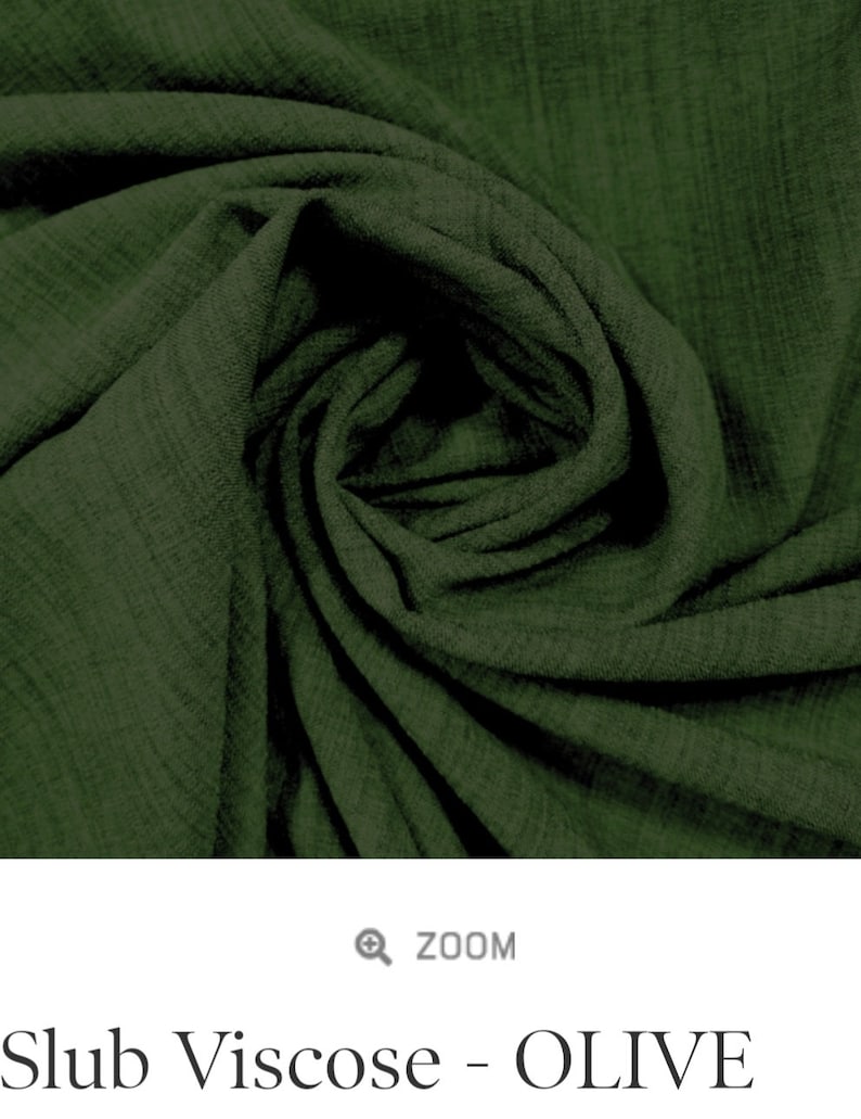May include: A close-up of a soft, green fabric with a textured, slubby weave. The fabric is folded and draped, showcasing its drape and texture.