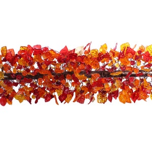 May include: A glass sculpture of a branch with red, orange, and yellow leaves. The leaves are made of glass and are arranged in a random pattern.