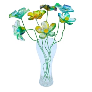 May include: A bouquet of glass flowers in shades of blue, green, and yellow in a clear glass vase.