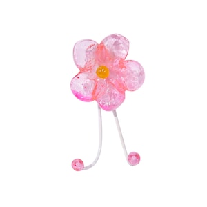 Könnte beinhalten: Haken in Form einer rosa Blume mit einem weißen Metallstiel und zwei rosa Kugeln am Ende des Stiels.
