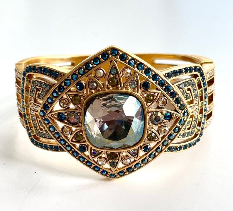 vintage Judith Lieber art deco clamper bracelet with sparkling faceted smoky quartz center stone with blue, clear, green and yellow swarovski crystal stones.    The bracelet is a magnetic clamper and is 7" x 2" i