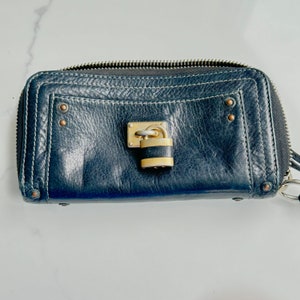 This is a vintage Chloe Paddington leather clutch wallet with lock and key.  The leather is like butter and all stitching is intact,  The signed Chloe lock has some wear to the gold, but is in working order.  The signed