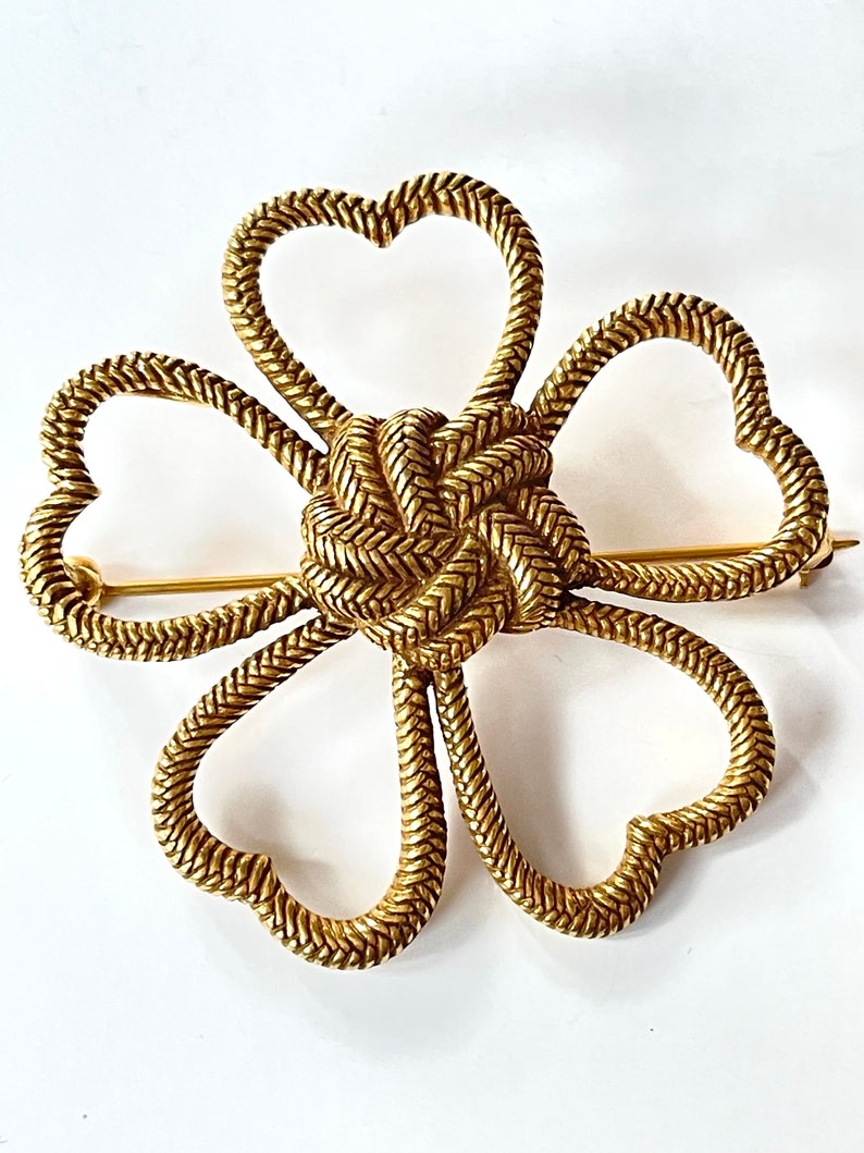 This is a lovely vintage flower brooch with Celtic lovers knot heart flower petals from the Metropolitan Museum collection.  Signed MMA.  2".   Wonderful vintage condition.