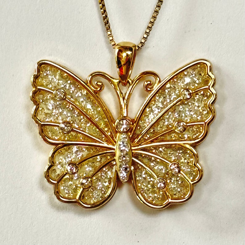 This is a stunning Jacmel Mauritus JCM gold plated over sterling silver with an open overlay of the butterfly wings with 8 crystal stones hovering over a layer of pave crystals set in ivory enamel.