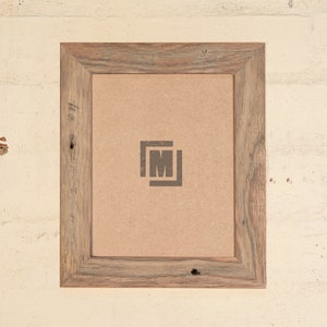May include: A rustic wood picture frame with a light brown wood finish. The frame has a simple design with a slightly raised edge. The frame is empty and ready to display a photo or artwork.