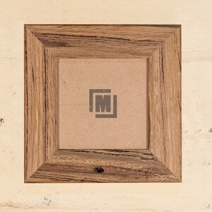 May include: A rustic wooden picture frame with a brown cardboard backing. The frame has a natural wood grain pattern and a dark brown finish. The frame is empty and ready for a photo or artwork.