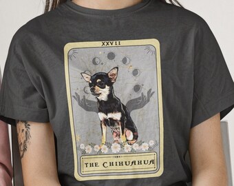 May include: A dark gray t-shirt with a tarot card design featuring a black and brown chihuahua. The card is titled "The Chihuahua" and has the Roman numeral XXVII at the top.