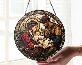 May include: A stained glass window hanging with a chain, depicting the Holy Family. The image shows Mary, Joseph, and baby Jesus in a colorful, detailed scene.