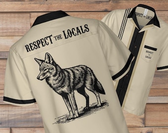 May include: Two beige bowling shirts with black trim. One shirt displays a coyote illustration and the text "Respect the Locals" on the back. The other shirt has a pocket with the same text and black stripes.
