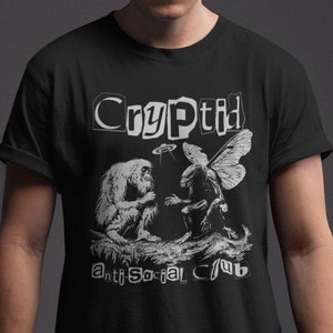 May include: Black t-shirt with a white graphic print of a cryptid, a mythical creature, with the text "Cryptid Anti-Social Club".