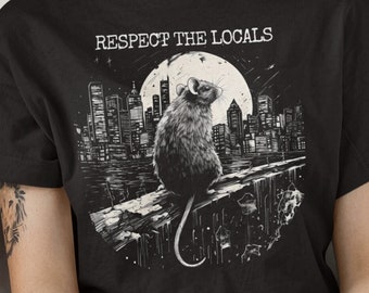 May include: Black t-shirt with a white graphic of a rat sitting on a ledge in front of a city skyline. The text "Respect the Locals" is above the rat.
