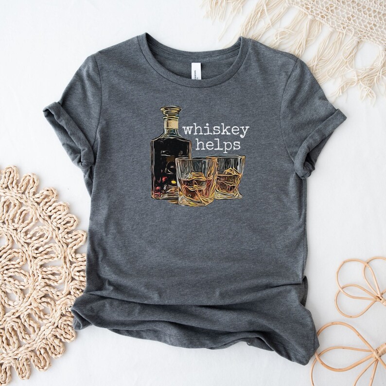 K&ouml;nnte beinhalten: Ein dunkelgraues T-Shirt mit einem Aufdruck einer Flasche und zwei Gl&auml;sern Whisky. Der Text "whiskey helps" ist in Wei&szlig; auf dem Shirt gedruckt.