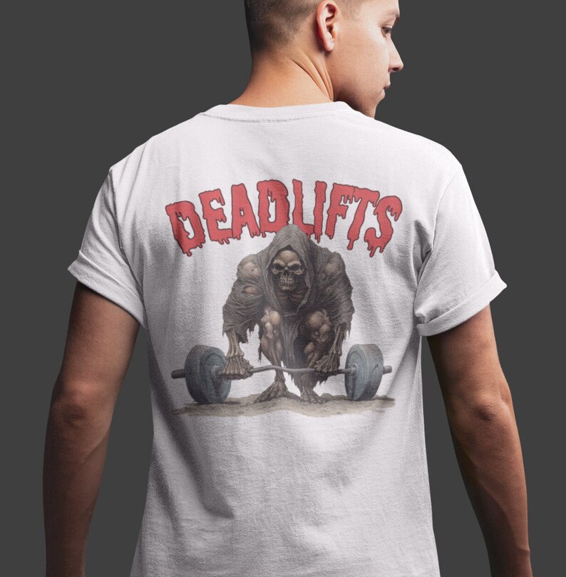 K&ouml;nnte beinhalten: Wei&szlig;es T-Shirt mit einer roten Grafik einer skelettartigen Figur, die eine Langhantel hebt. Der Text "DEADLIFTS" befindet sich &uuml;ber der Figur.