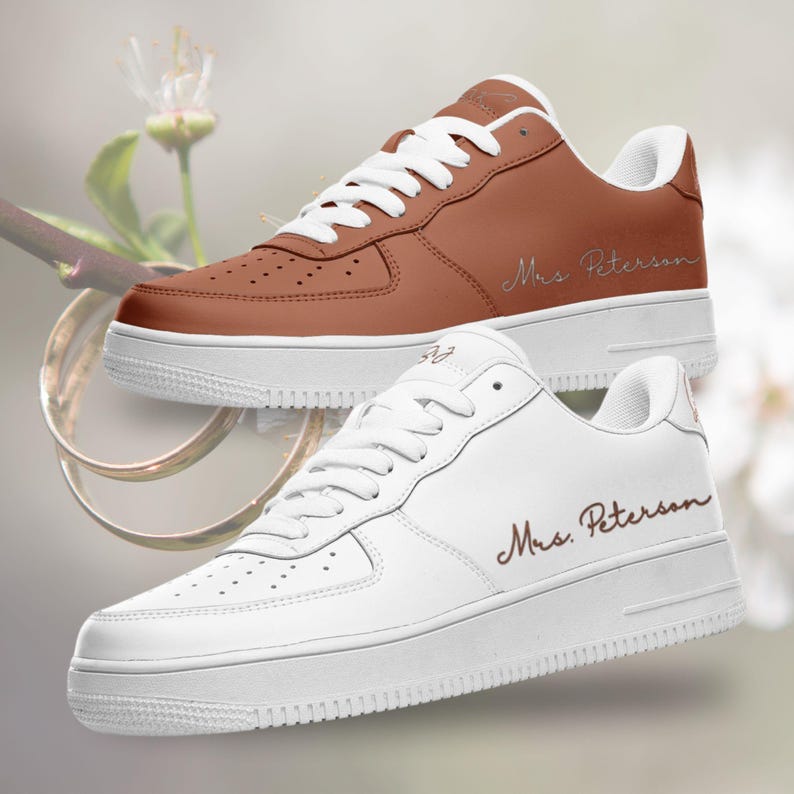 May include: Two pairs of white sneakers with brown leather accents. One pair is brown and the other is white. Both pairs have the text "Mrs. Peterson" written on the side.