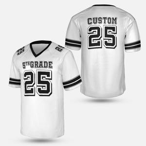 K&ouml;nnte beinhalten: Wei&szlig;es Football-Trikot mit schwarzen Akzenten, das die Nummer 25 in fetter, schwarzer Schrift zeigt. Auf der Vorderseite steht "5th GRADE" &uuml;ber der Nummer. Auf der R&uuml;ckseite des Trikots steht "CUSTOM" &uuml;ber der Nummer 25. Schwarze Streifen zieren die &Auml;rmel.