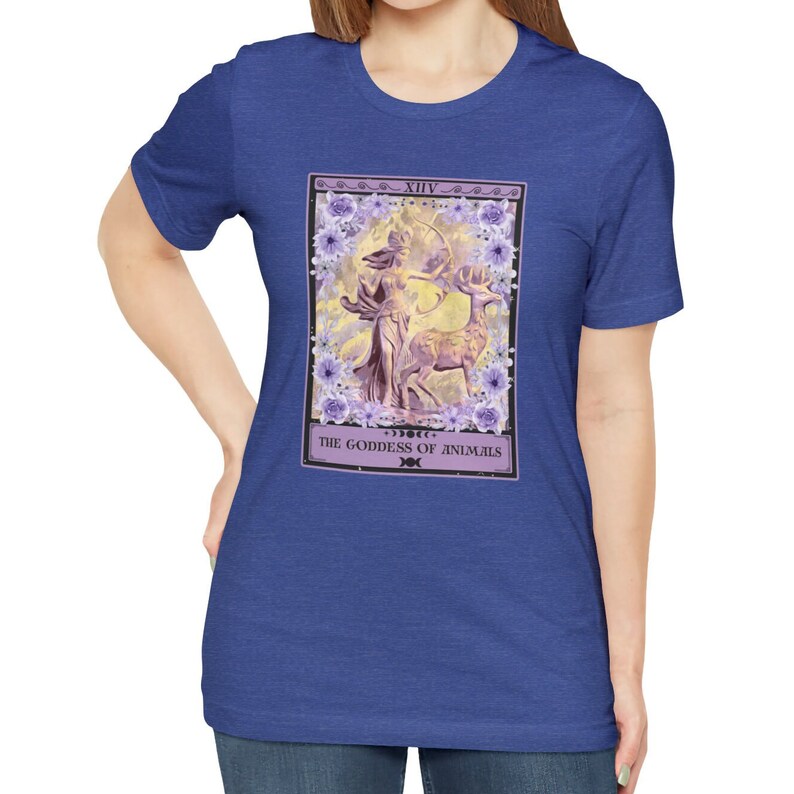 May include: A royal blue t-shirt with a tarot card design featuring a woman with a bow and arrow and a deer. The card is titled "XIV - The Goddess of Animals".