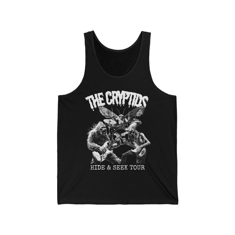 May include: Black tank top featuring a white graphic of a band with a gorilla, a skeleton, and a moth playing instruments. The text "THE CRYPTIDS" is above the band, and "HIDE & SEEK TOUR" is below.