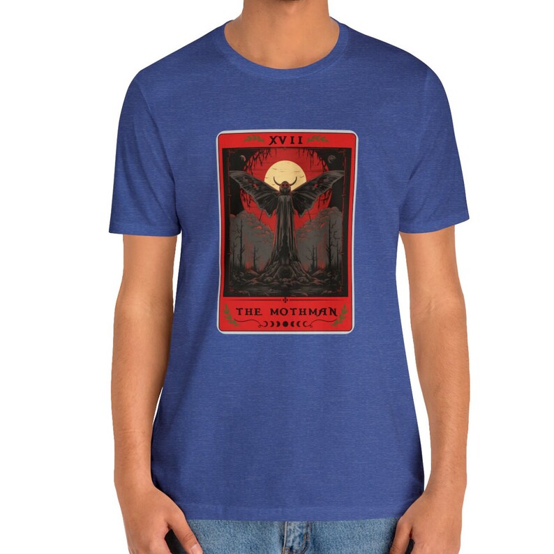 May include: A blue t-shirt featuring a red tarot card design with a mothman and the text "XVIII THE MOTHMAN" on the card.