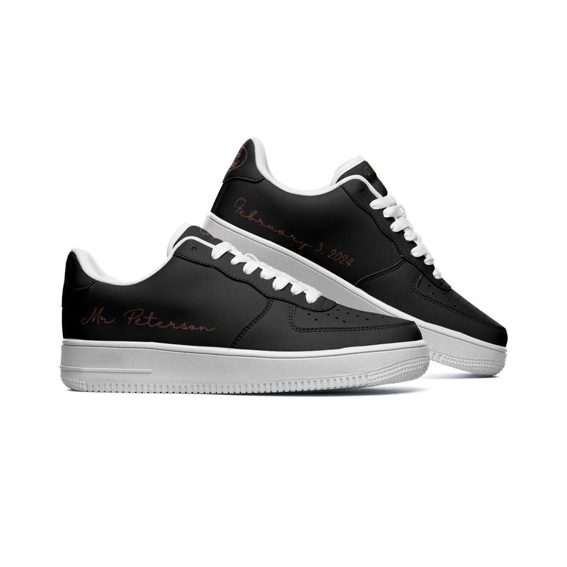 May include: A pair of black leather sneakers with white soles. The left shoe has the text "Mr. Peterson" written on the side in a cursive font. The right shoe has the text "February 3, 2024" written on the side in a cursive font.
