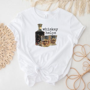 K&ouml;nnte beinhalten: Wei&szlig;es T-Shirt mit einem Aufdruck einer Flasche Whiskey und zwei Gl&auml;sern. Der Text "whiskey helps" ist auf dem Shirt gedruckt.