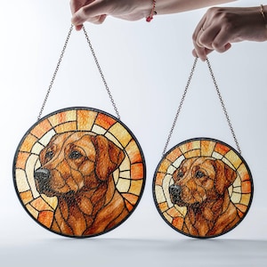May include: Two round stained glass dog portraits with a brown and orange color scheme. Each piece features a Labrador Retriever's head and shoulders, framed by a black border and a chain for hanging.