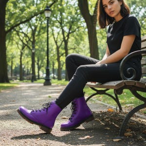 May include: A pair of purple, lace-up boots with a textured design. The boots have a brown sole and are worn by a person sitting on a park bench. The boots are a vibrant shade of purple.